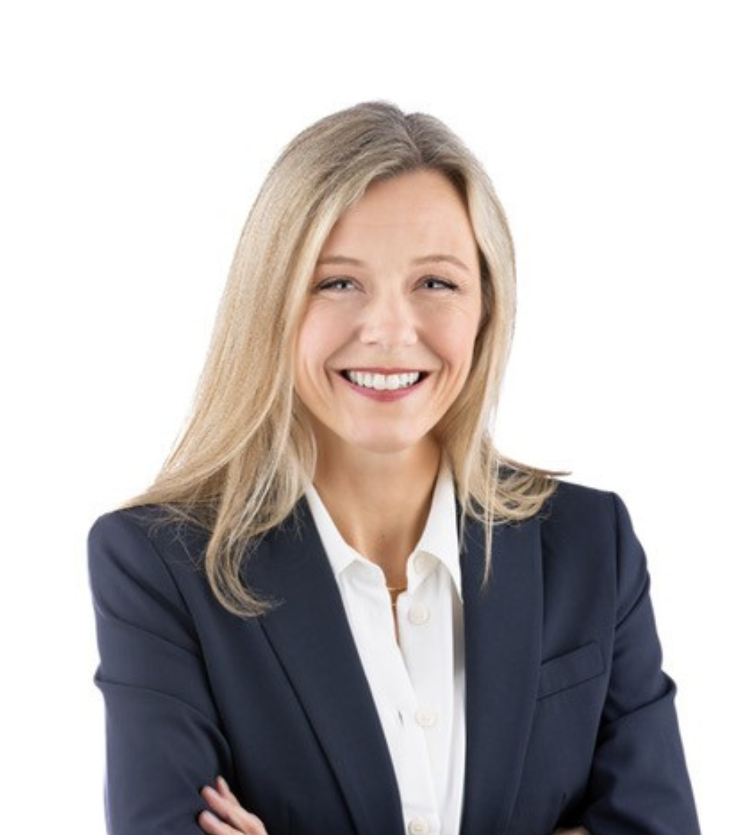 Professional woman in a navy blazer smiling at the camera, arms crossed in a business portrait.